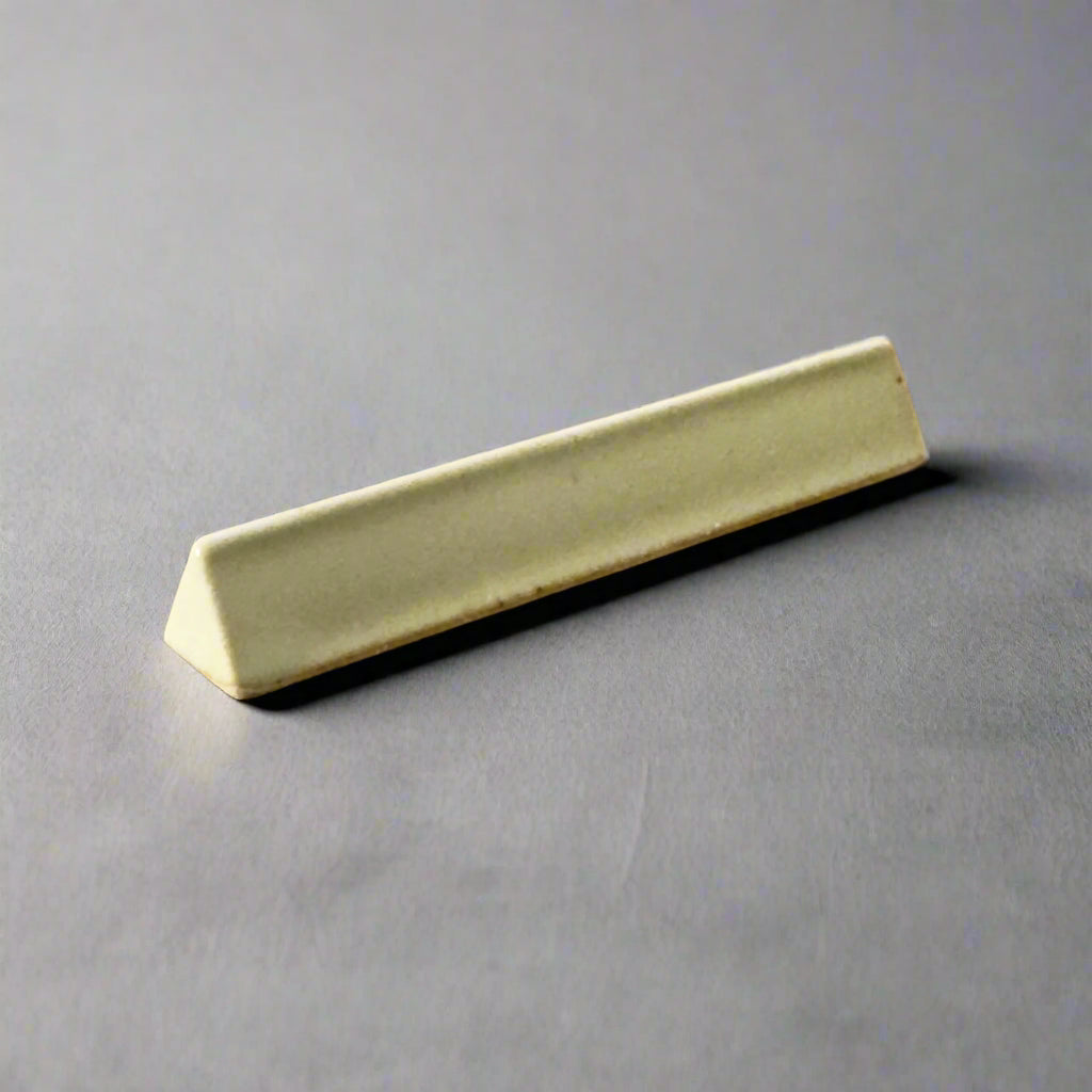 A triangular cutlery rest in cream colour, made in Japan. Available at Toka Ceramics.