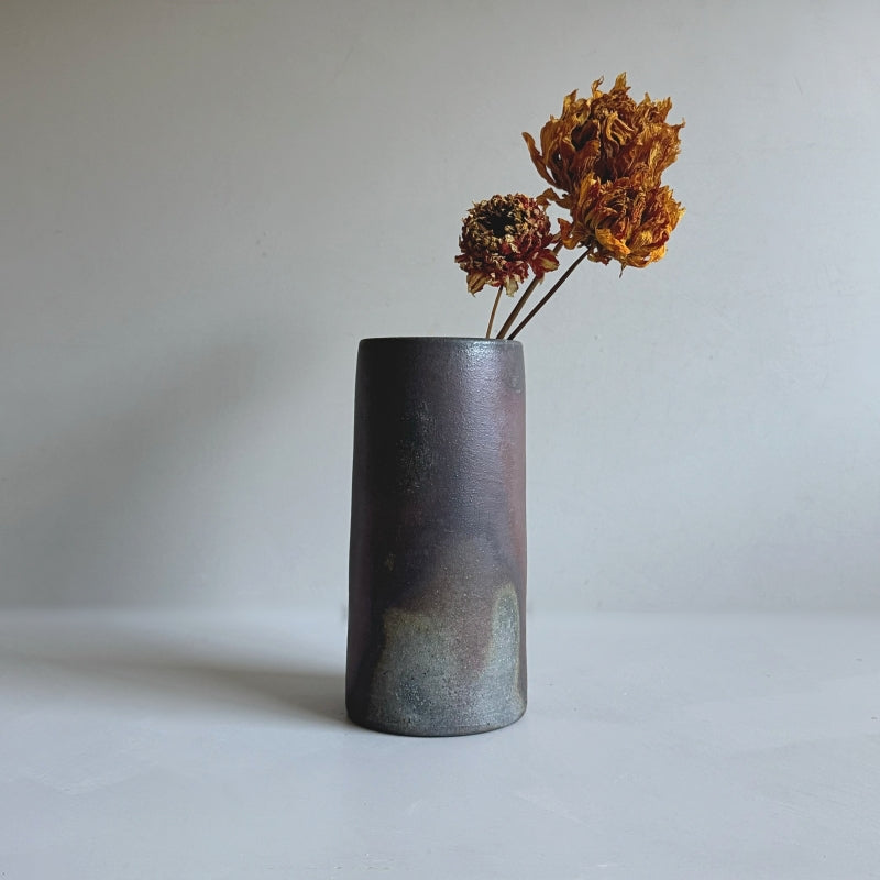 An earthy brown vase handcrafted by Tsugaru Kanayama Pottery in Japan. Large cylinder shape. Available at Toka Ceramics.